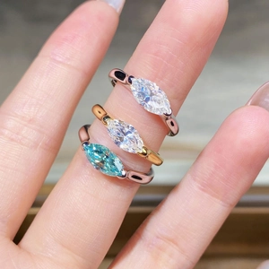 Three marquise-cut moissanite rings in silver, gold, and rose gold finishes on hand