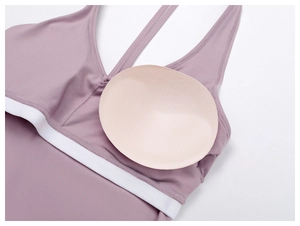 Detail of purple sports bra featuring removable chest pads and white elastic band
