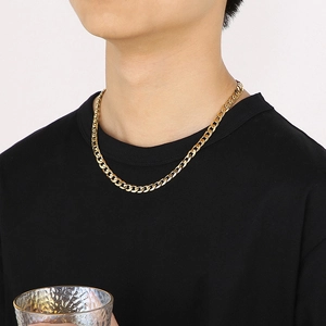 Golden titanium steel curb chain necklace worn by a model over a black t-shirt