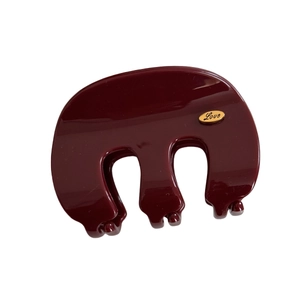 French luxury deep red glossy hair claw clip with golden Love logo on white background