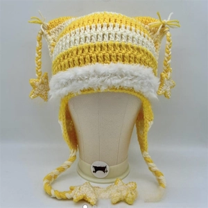 Detail of yellow and white handmade crochet earflap hat with star charm and cat ears