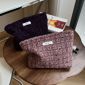 Detail of tweed woven makeup bags in purple and pink with minimalist textile labels