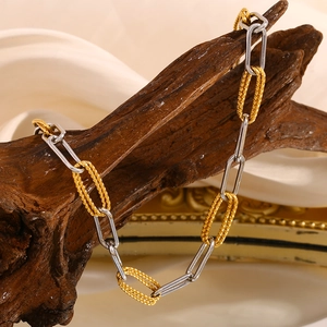 Close-up of 18K gold and silver plated paperclip link chain on natural wood background