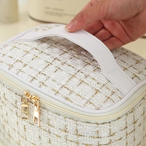 White tweed makeup bag with gold thread weave and leather handle for travel