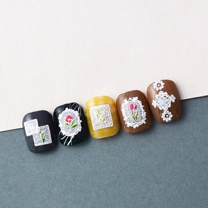 Detail of 5D embossed white lace floral patterns on various colored press-on nails