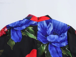 Gros plan détaillé de l'imprimé floral et du col montant sur une robe longue plissée