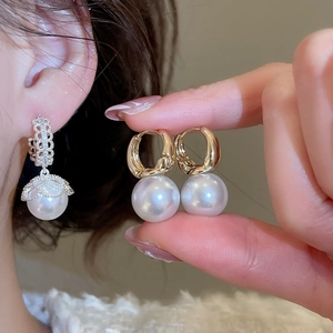 Close-up of French vintage round pearl earrings with silver floral caps and gold hoops