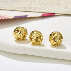 Macro detail of three hollow vintage gold alloy round beads for DIY jewelry making