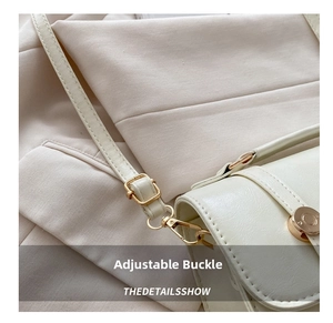 Detail of adjustable golden metal buckle and lobster clasp on ivory leather backpack strap