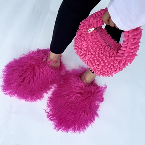 Close-up of bright rose pink plush handbag and matching faux fur slippers set
