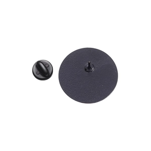 Close-up of circular black metal pin back with matte texture and rubber butterfly clutch