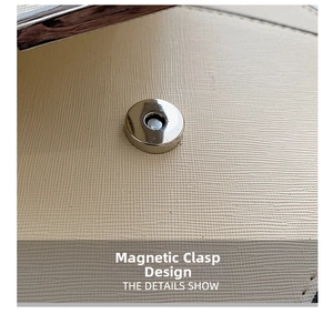 Close-up of beige crossbody bag showing cross-grain leather texture and silver magnetic clasp