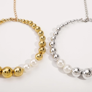Detailed macro view of gold and silver metallic beads mixed with white pearls on a choker