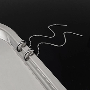 Detail of silver long chain tassel ear cuff with sparkling zircon stone accents