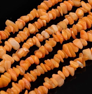 Macro shot of natural orange irregular stone beads for DIY jewelry making on black background
