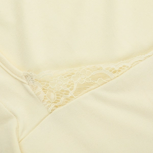 Détail du haut crème à manches longues avec dentelle délicate et texture en maille douce