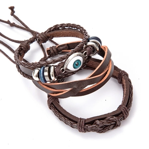 Macro shot of vintage multilayer leather bracelets with blue evil eye charm details