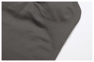 Macro view of dark grey seamless knit fabric showing detailed ribbed texture and stitching