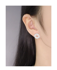 Detailed view of silver S925 earrings with lava texture on female model's ear