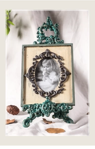 Detalle de marco de fotos vintage de hierro con tallas de metal y pátina de bronce