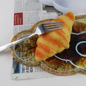 Detailed view of DIY resin tray mold with finished gold foil tray on newspaper
