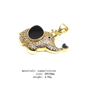 Detail view of a gold elephant pendant with black stones and dimensions 28x19mm
