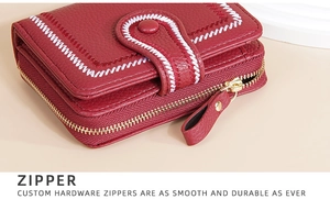 Detailed close-up of durable golden metal zipper and stitching on the red women wallet