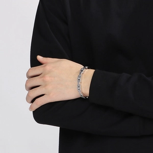 Close-up of a silver watch-band style stainless steel bracelet with diamonds on male wrist