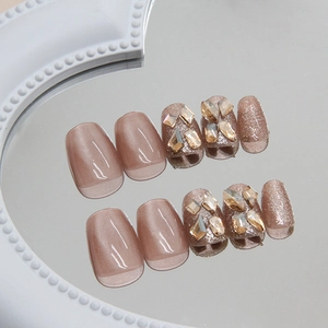 Sparkling cat eye press-on nails with champagne glitter and brown geometric rhinestones