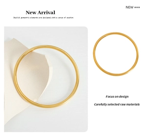 Dettaglio di un bracciale minimalista in acciaio al titanio placcato oro tondo
