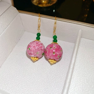 Detailed close-up of Neo-Chinese ceramic drop earrings with green and pink glaze beads