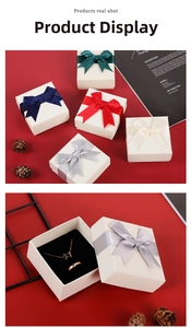 Detail of square jewelry gift box with satin bow and black velvet lining for ring and necklace
