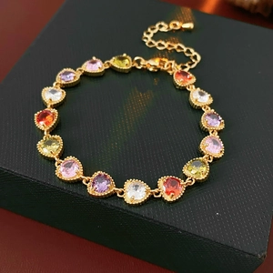 Detail of colorful heart-shaped gemstone bracelet with gold chain on jewelry box