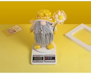 Macro detail of bee gnome plush toy on a digital scale showing weight of 169 grams