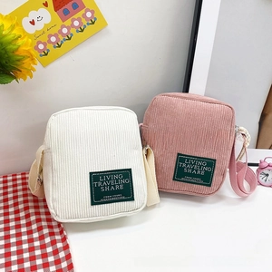 Detailed macro view of ivory and dusty pink corduroy square bags with canvas straps