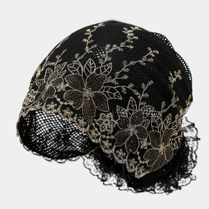Detail of black lace cap featuring gold floral embroidery and scalloped lace edges