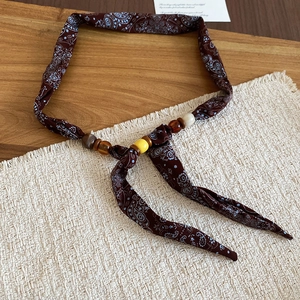 Detail of bohemian paisley fabric necklace with multi-color resin beads and wooden accents
