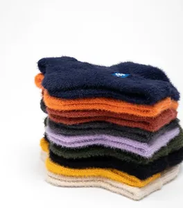 Gros plan de bonnets d'hiver épais en tricot de couleurs avec texture pelucheuse