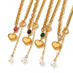 Detail of heart pendants and pearls on gold layered stainless steel necklaces