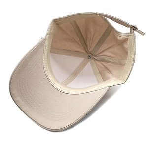 Detailed interior of khaki cotton baseball cap showing six-panel stitching and metal buckle