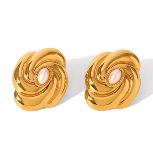 Macro detail of golden spiral flower earrings featuring central white pearls