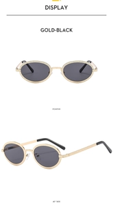 Detail view of vintage oval sunglasses with textured gold metal frames and black lenses