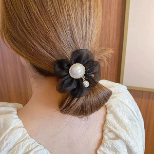 Détail d'un chouchou fleur en organza noir élégant avec perles et accents de cristal