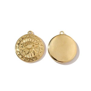 Detail of golden stainless steel round pendants with ancient Egyptian Eye of Horus engraving