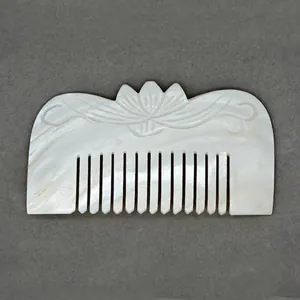 Handcrafted mother of pearl shell comb featuring elegant lotus flower relief carving