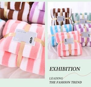 Detail showing soft coral fleece striped towel set tied with a golden elegant ribbon