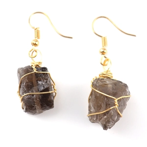 Detail of handmade wire-wrapped smoky crystal earrings with natural raw stone texture