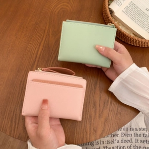 Short minimalist cross-grain leather wallet with zip pocket and card slots in mint and pink