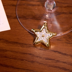 Gros plan d'une boucle d'oreille étoile dorée sertie de strass sur un support en bois sombre