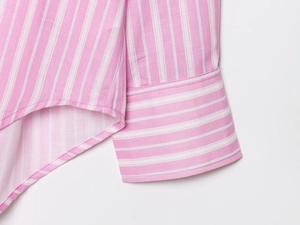 Close-up of pink and white striped shirt showing precise stitching on cuffs and hem details
